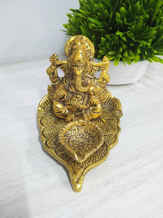BEAUTIFUL GANESH STATUE ON FLOWER DIYA INDIAN RELIGIOUS RETURN GIFT METAL STATUE. METAL GANESH GOLD POLISH WITH DIYA ON LEAF FOR HOME DECOR AND GIFT PURPOSE SMALL SIZE (GOLD)